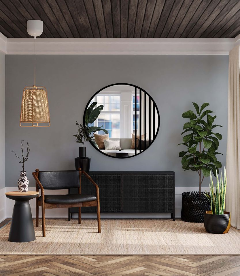 Stilvolles Interieur mit rundem Spiegel mit schwarzen Sprossen, dunkler Holzdecke, Ledersessel und grünen Pflanzen in Töpfen, gestaltet in einem modernen Loft-Stil.